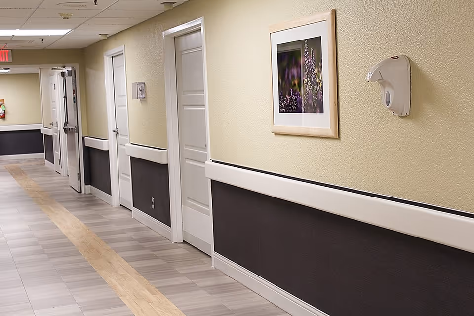 Long hallway in a senior living facility with doors along the walls.