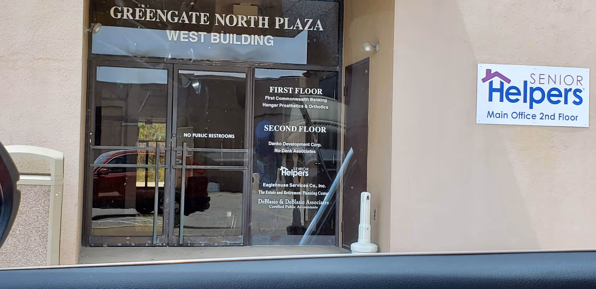 Entrance to Senior Helpers facility with glass doors and signage on a beige exterior wall.