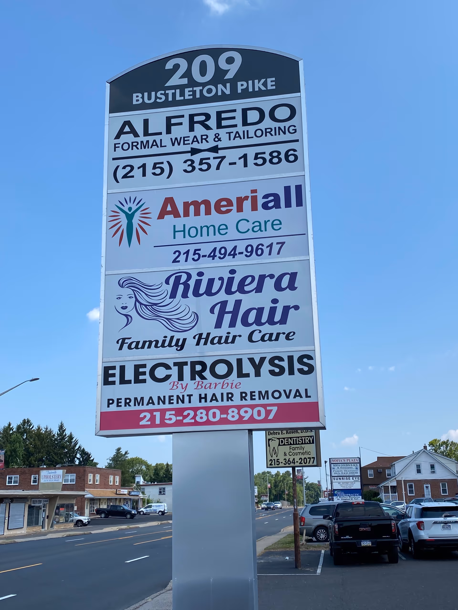 Tall outdoor signboard with Ameriall Home Care and other ads beside a busy street.