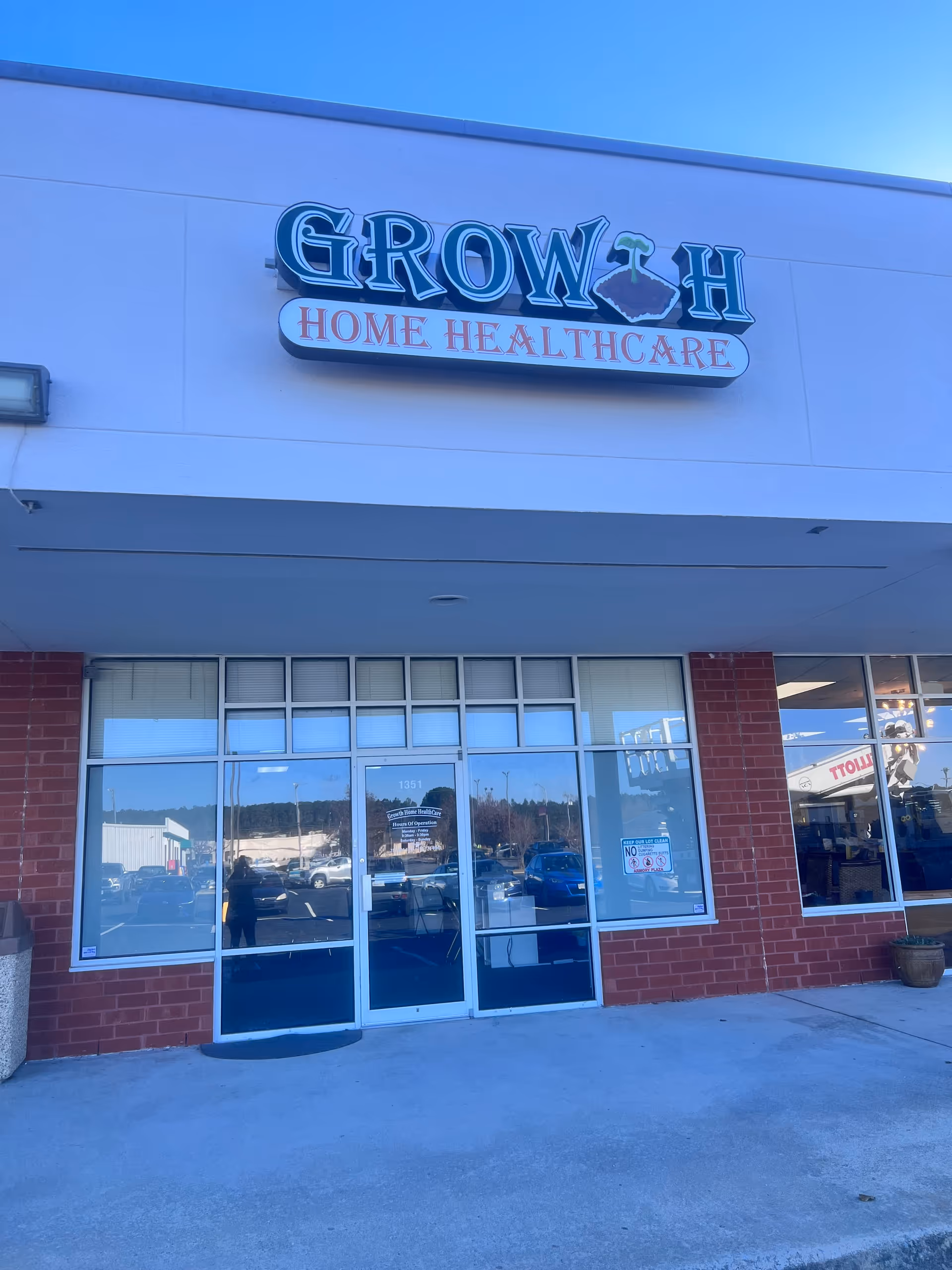 Exterior view of Growth Home Healthcare storefront with glass doors and brick facade.