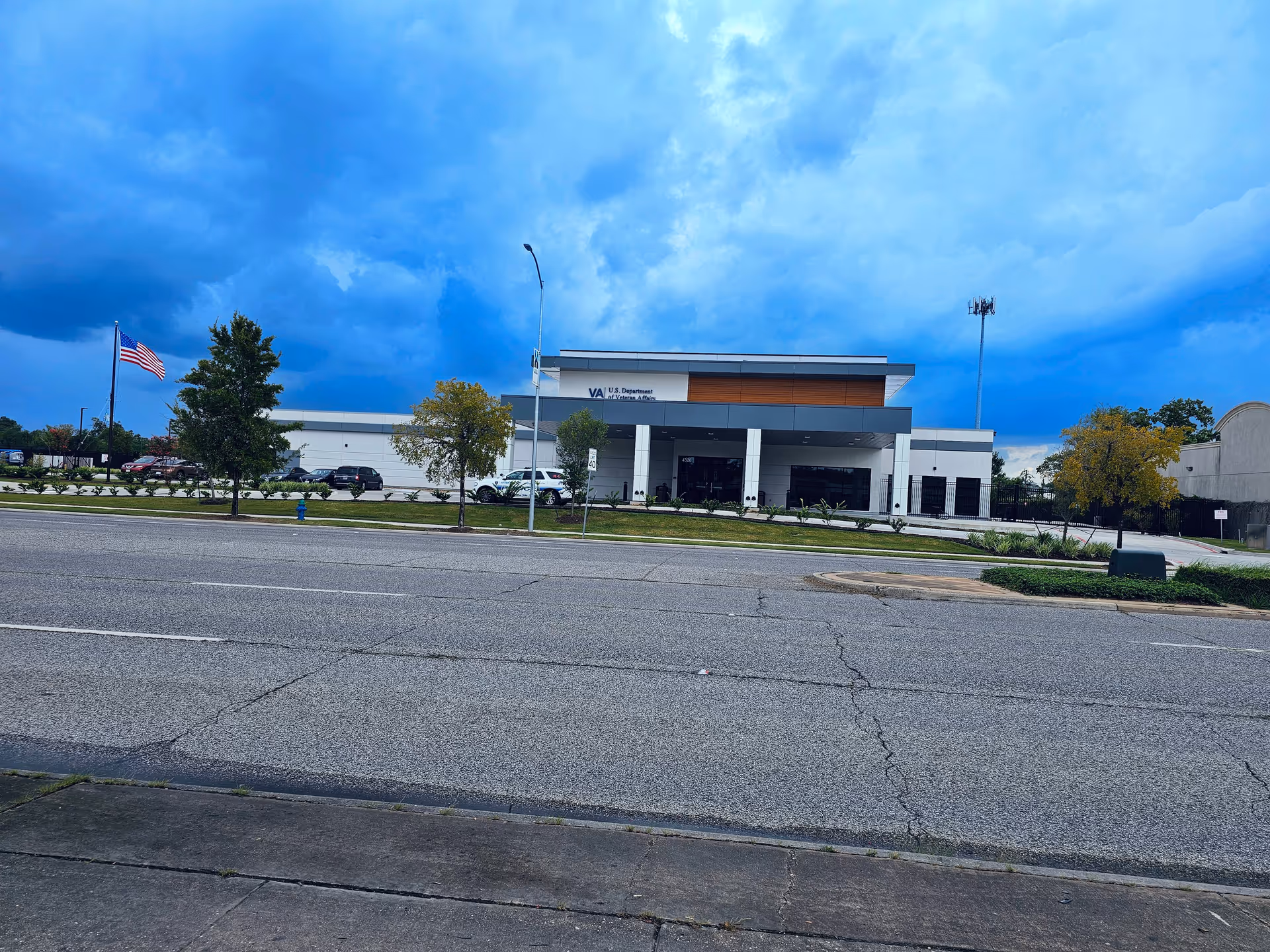 Exterior front of a U.S. Department of Veterans Affairs facility with flag and large entrance.