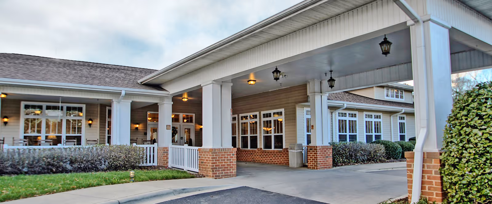 Exterior view of Evergreen Senior Living entrance with covered walkway and brick columns