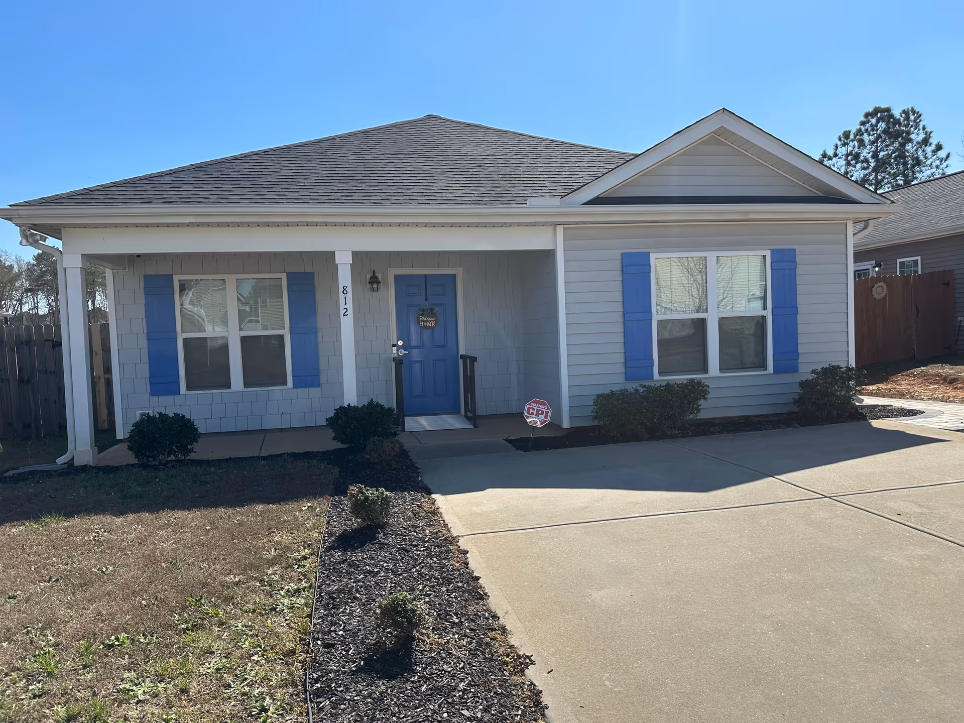 Single-story house with a blue front door and matching blue shutters.