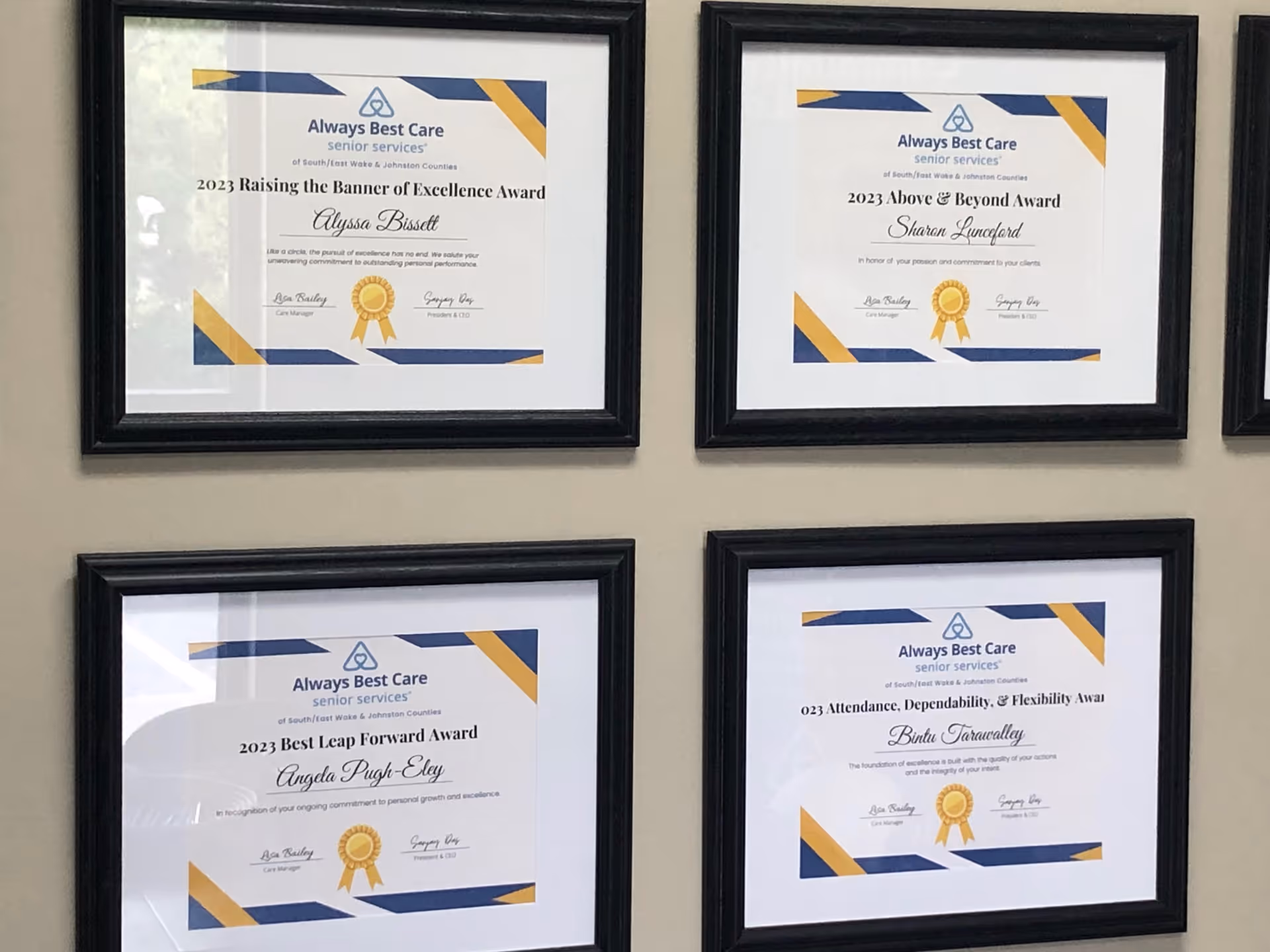 Wall with four framed Always Best Care awards certificates in black frames.