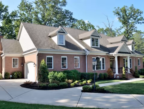 Front view of a brick senior living building with manicured landscaping.