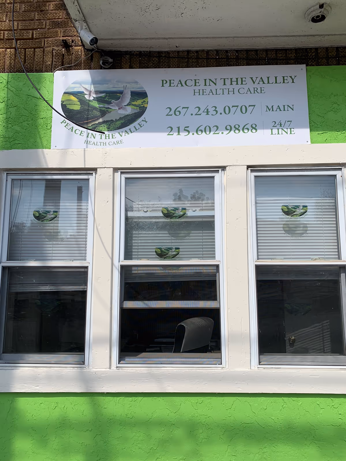 Exterior of a building with a Peace in the Valley Health Care sign and three windows.