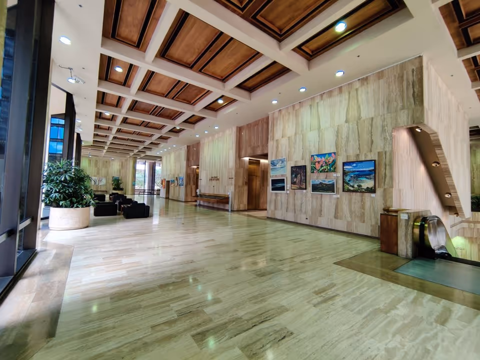 Spacious senior-living facility lobby with marble floors, wall art, plants, and seating.