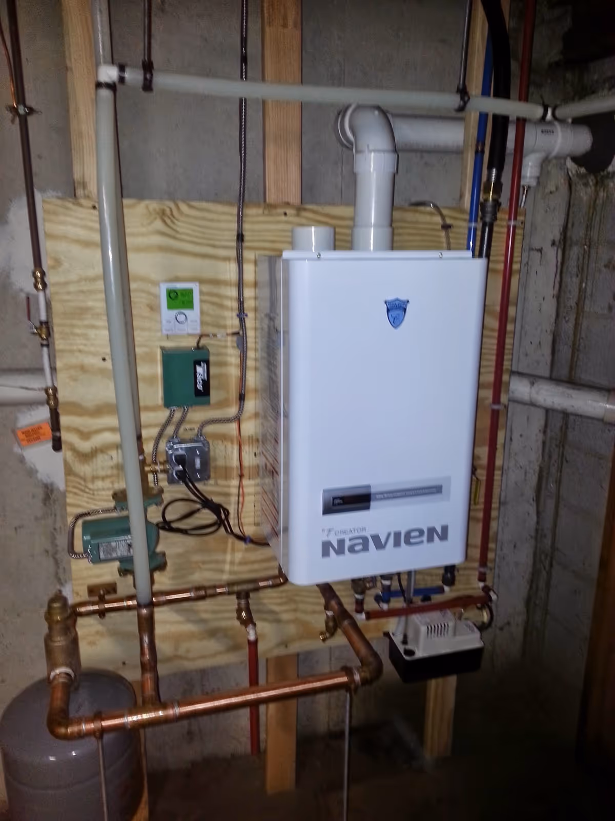 Basement utility area with a Navien boiler and copper piping.