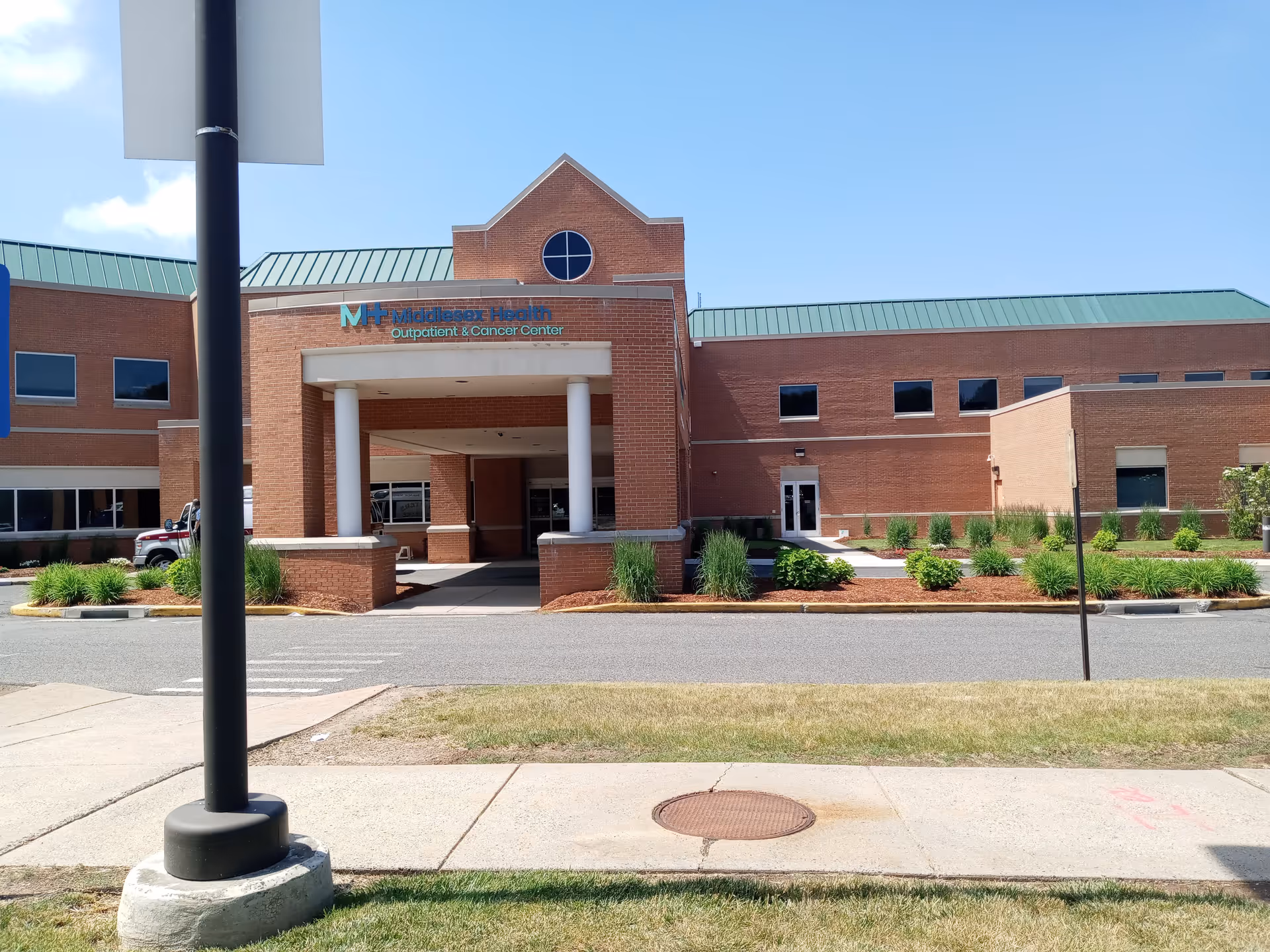 Exterior view of a brick medical center with a portico entrance and landscaped front