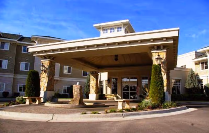 Exterior view of Fairwinds - Sand Creek entrance with porte-cochère and landscaped circle drive.