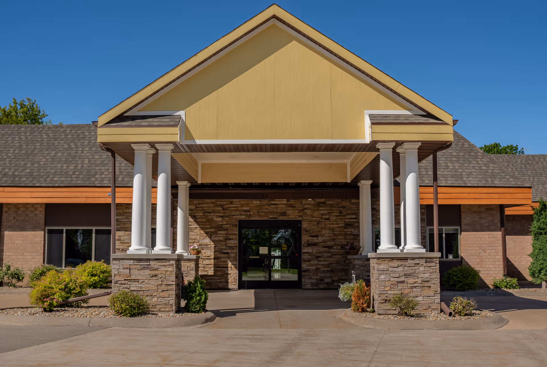 Front entrance of Eden Vista Ripon senior living facility with stone columns