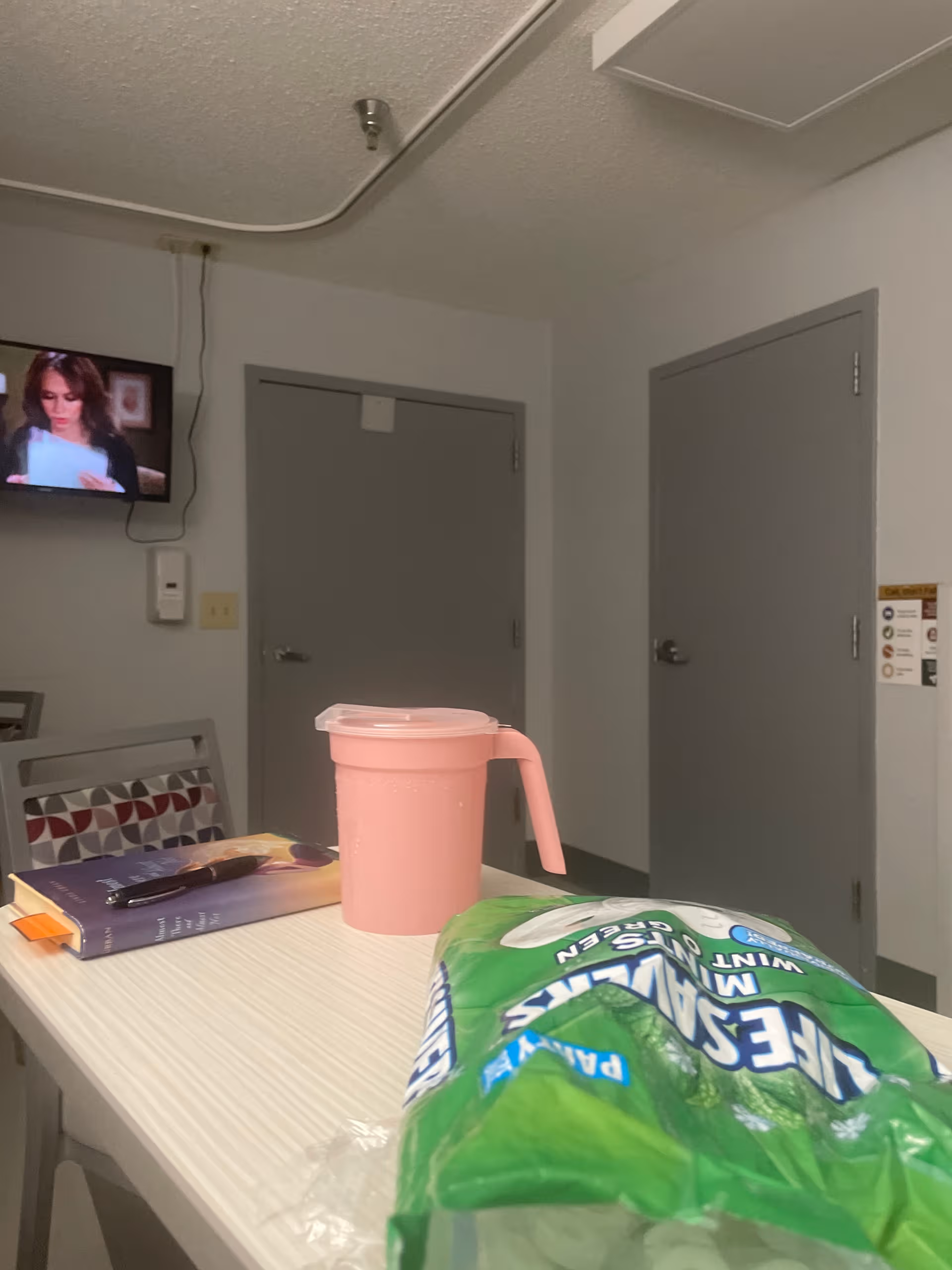 Interior view of a dining area with a pink pitcher and snack bag on a table.