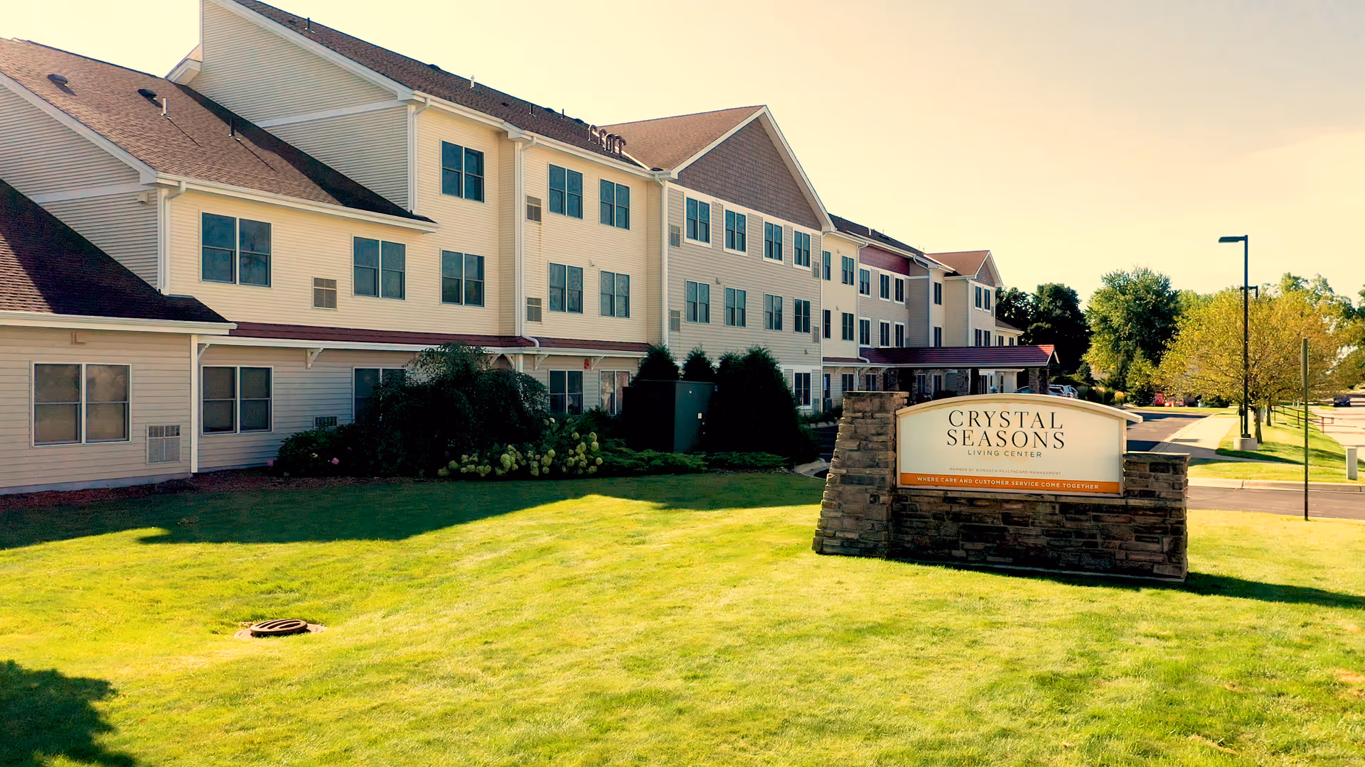 Exterior view of Crystal Seasons Living Center with a lawn and sign.