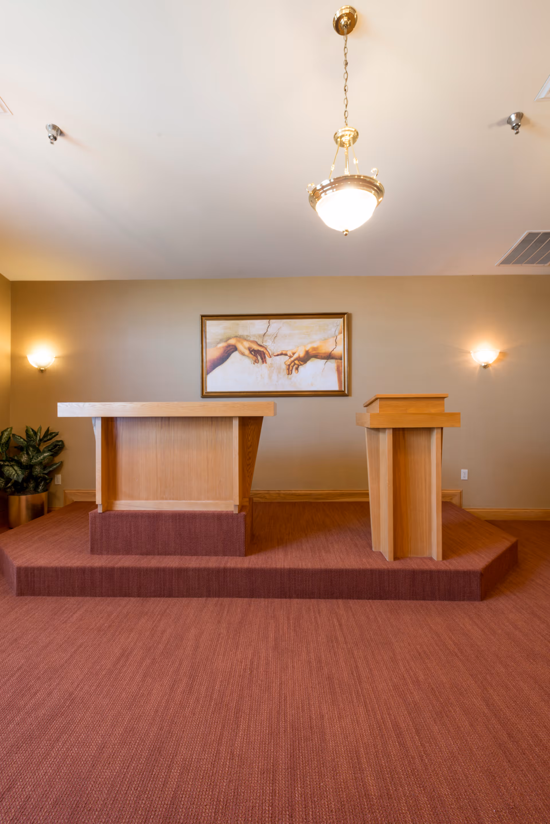 Two wooden lecterns on a raised maroon platform in a meeting room.