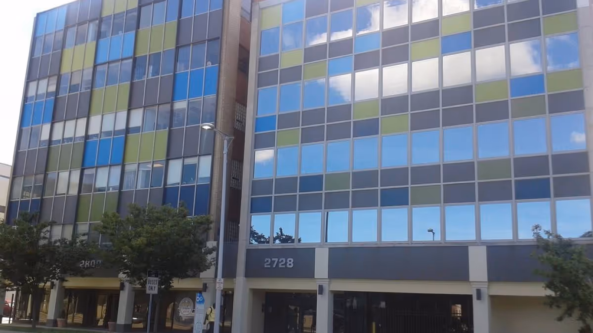 Colorful paneled glass facade of a modern multi-story building exterior.