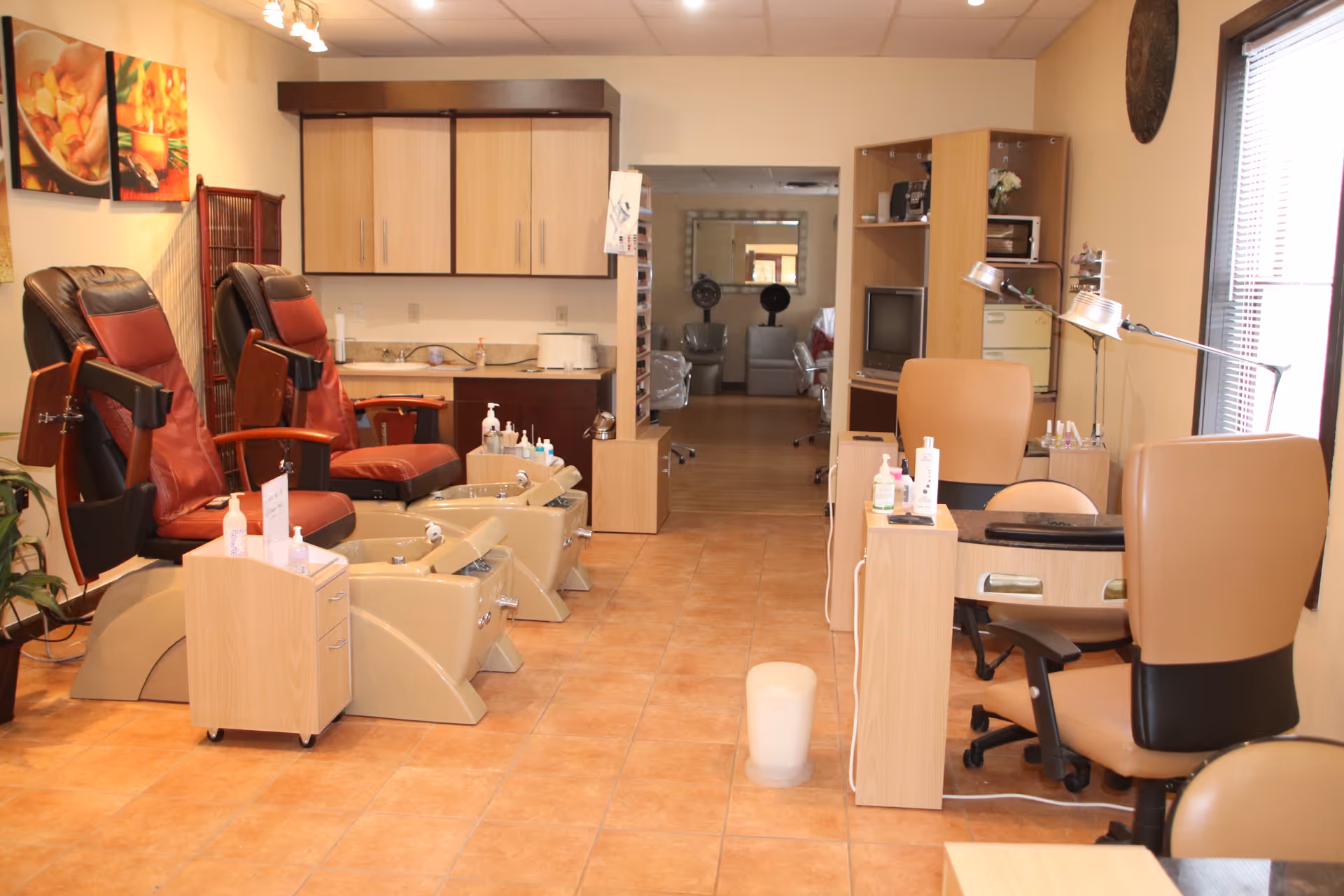 Nail and spa treatment area with pedicure chairs, desks, and cabinets in a senior facility.
