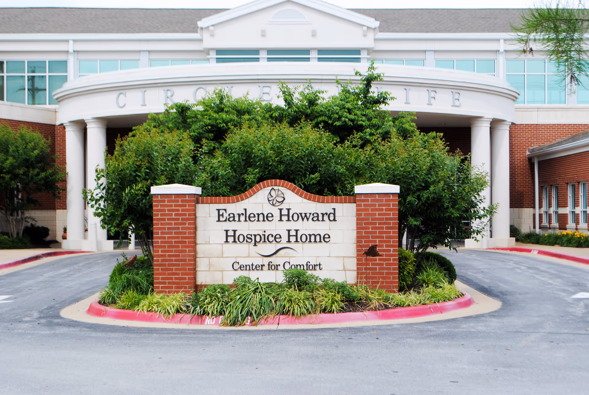Exterior view of Circle of Life facility with Earlene Howard Hospice Home sign at entrance.