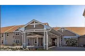 Exterior view of Mill Pond senior living facility with covered entryway and parking.