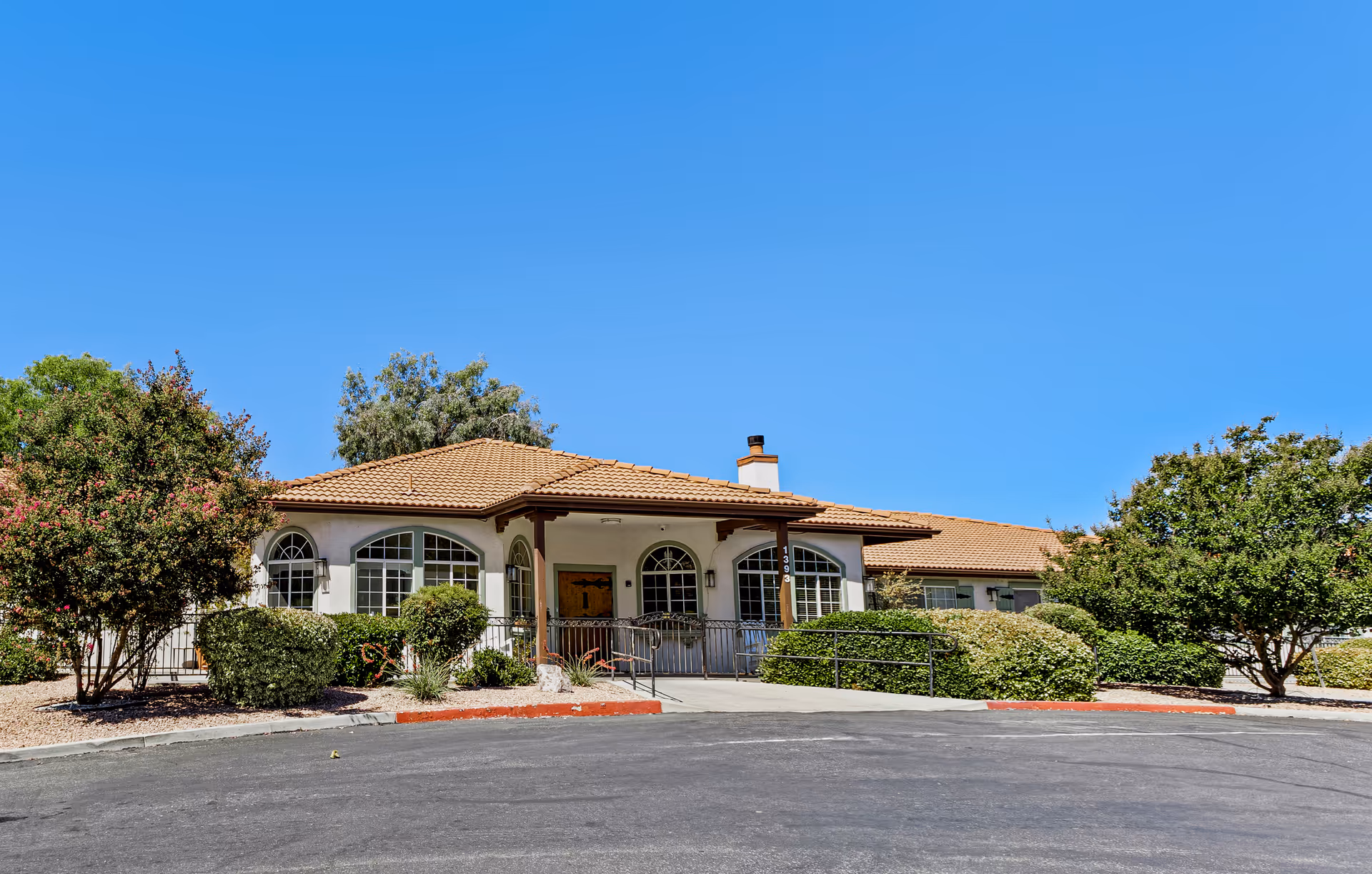 Front view of Buena Vista Assisted Living building with covered entrance and landscaped shrubbery.