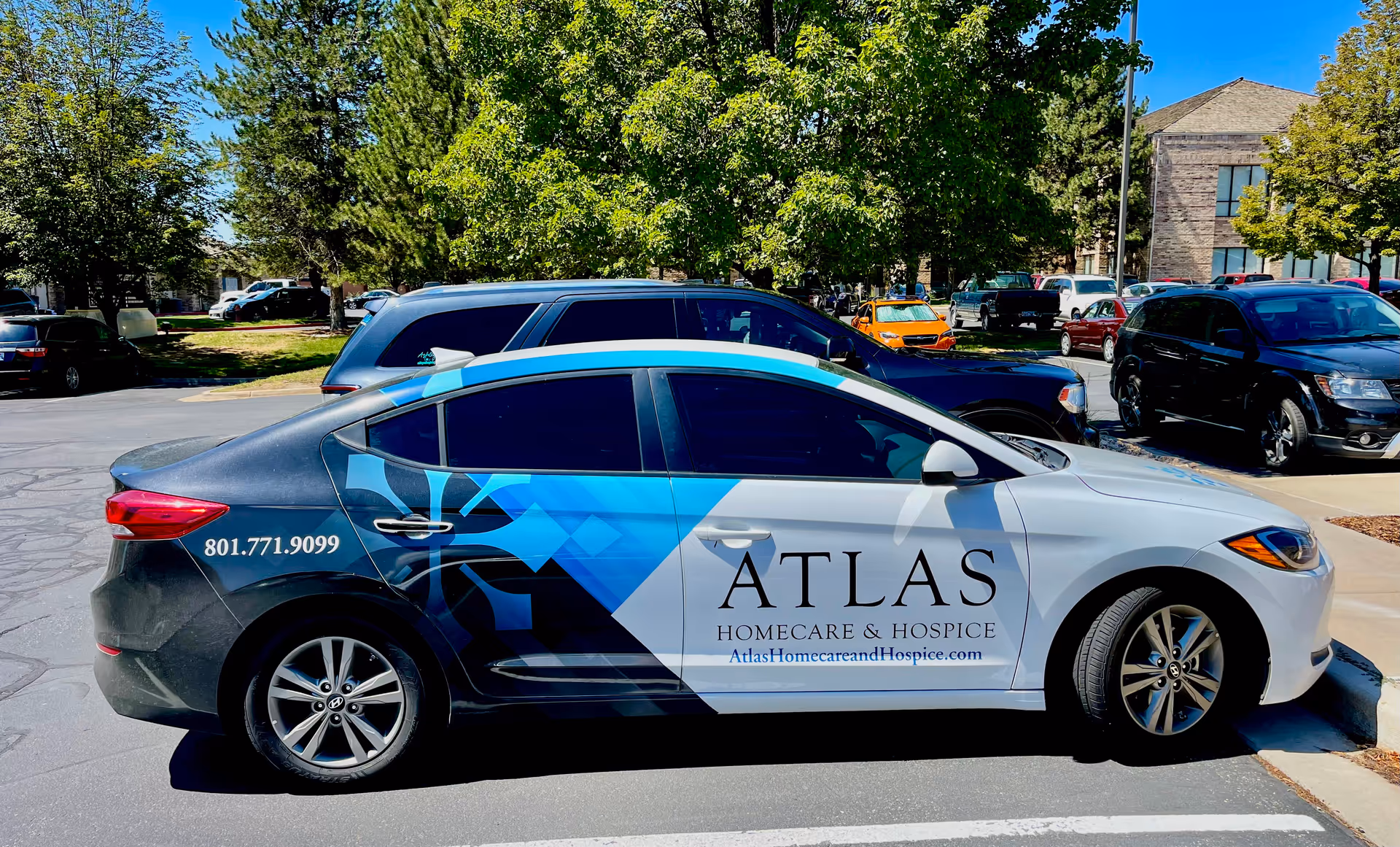 Atlas Homecare and Hospice van with blue graphics parked in a sunny lot.