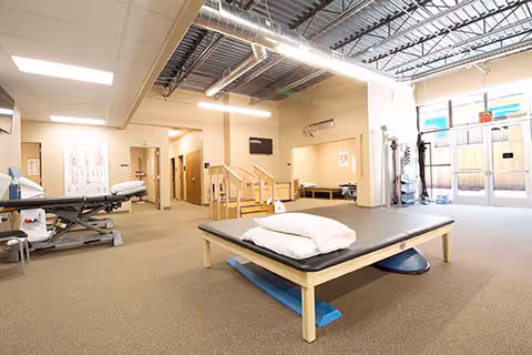Therapy room with treatment beds, equipment, and open layout inside a rehabilitation facility.