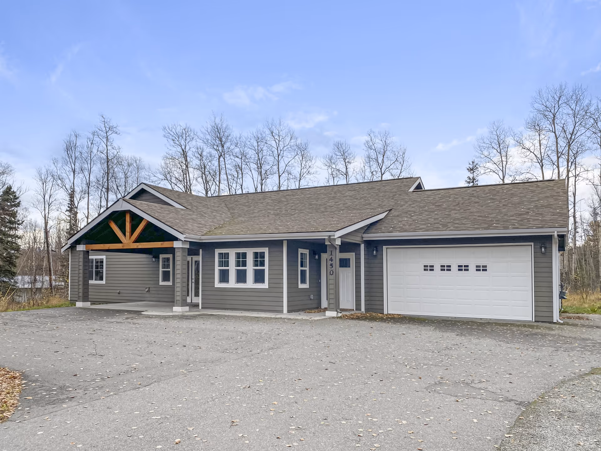 Front view of a gray, single-story building with a large white garage door.