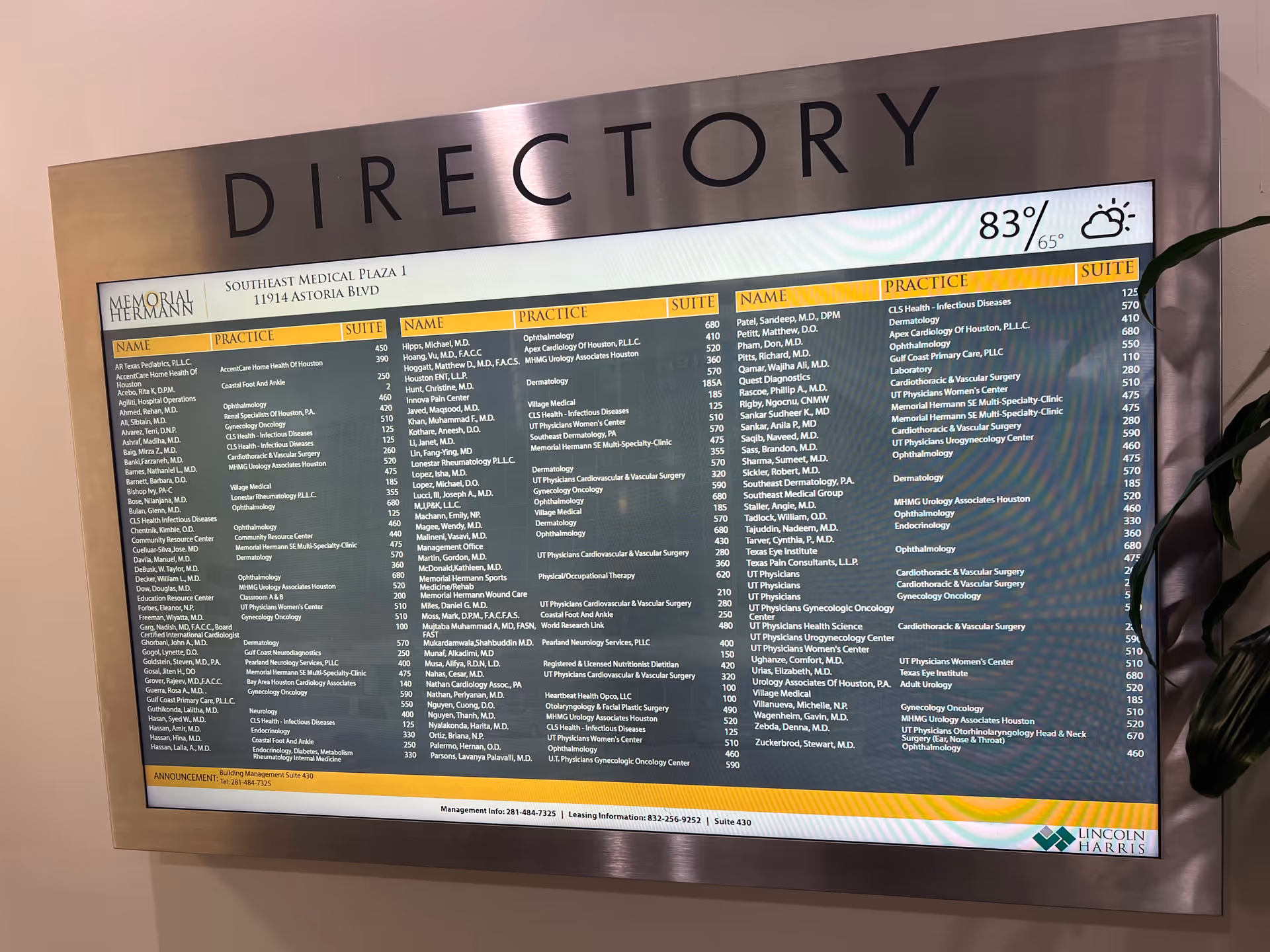 Backlit directory board listing practitioners in a medical facility lobby.