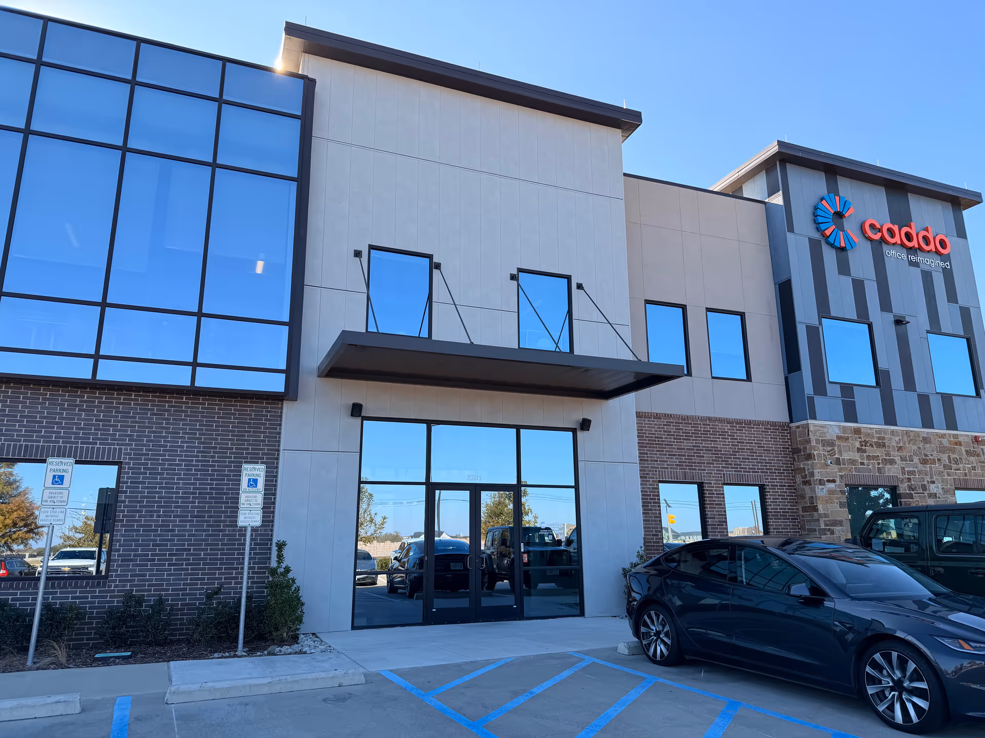 Modern commercial building exterior with glass windows and a central entrance.