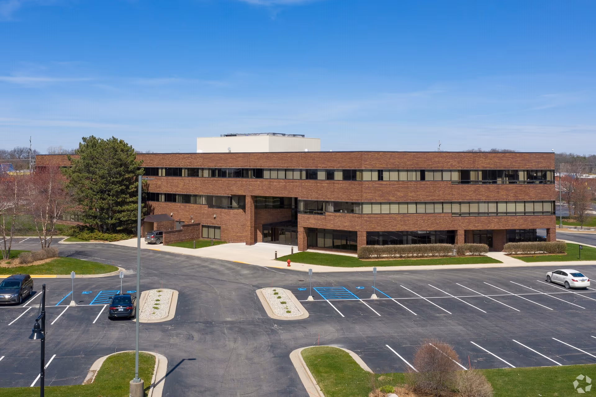 Front exterior of Alpine Care Home Health, a brick building with parking and manicured landscaping.