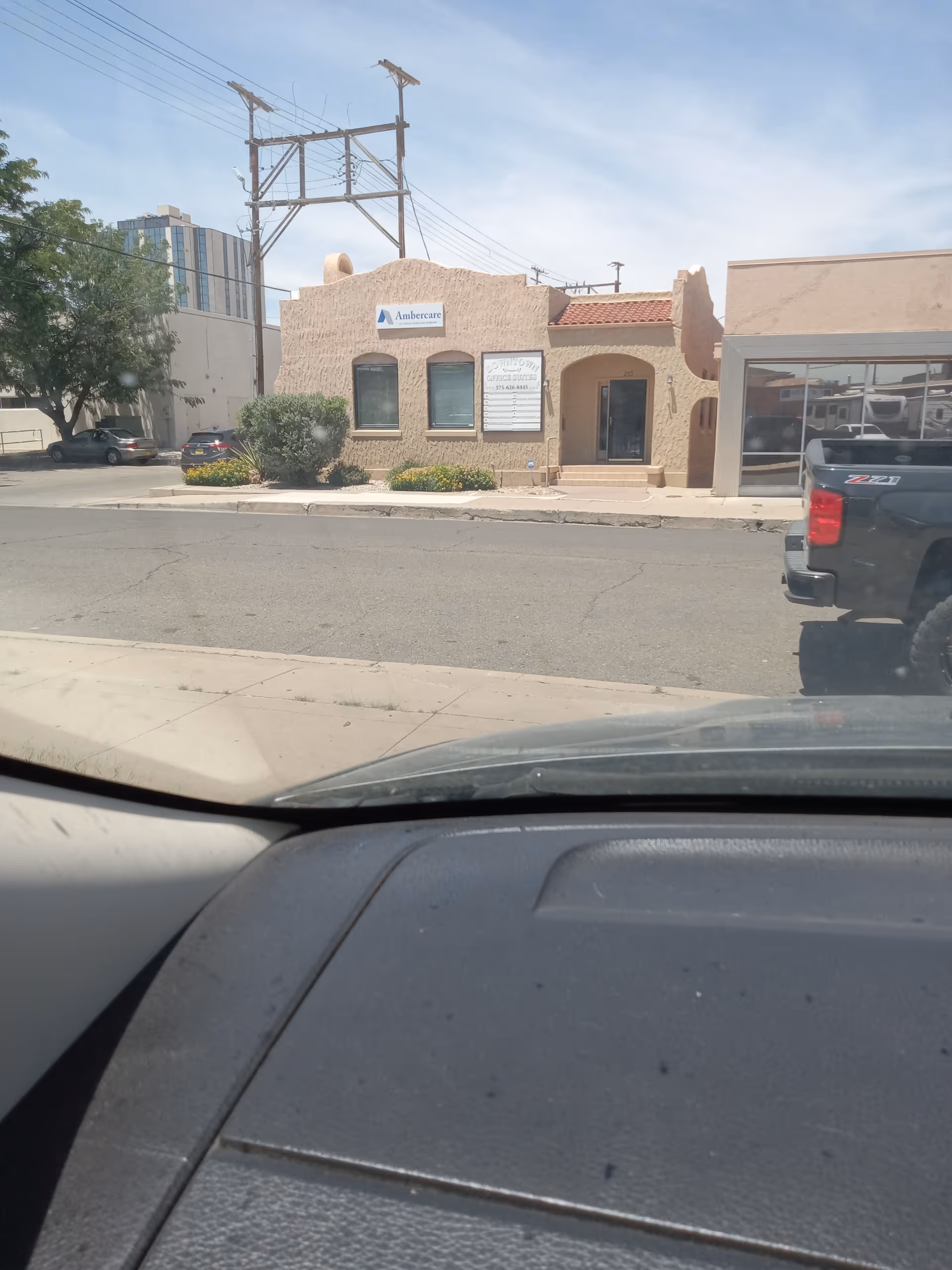 Street view of an Ambercare senior living building with a stucco front and signage.