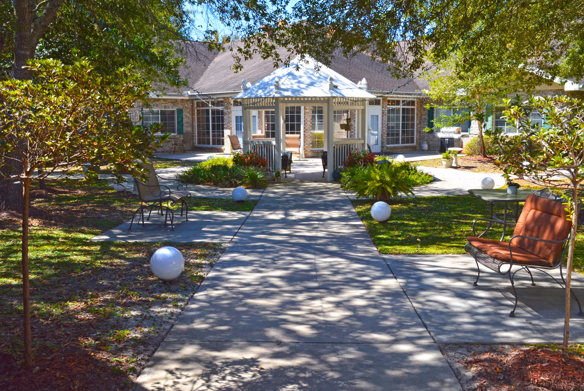 Outdoor courtyard with walkway, gazebo, and seating in front of Brookdale Canopy Oaks.