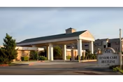 Exterior view of Senior Care Beltline facility entrance with porte-cochere and sign.