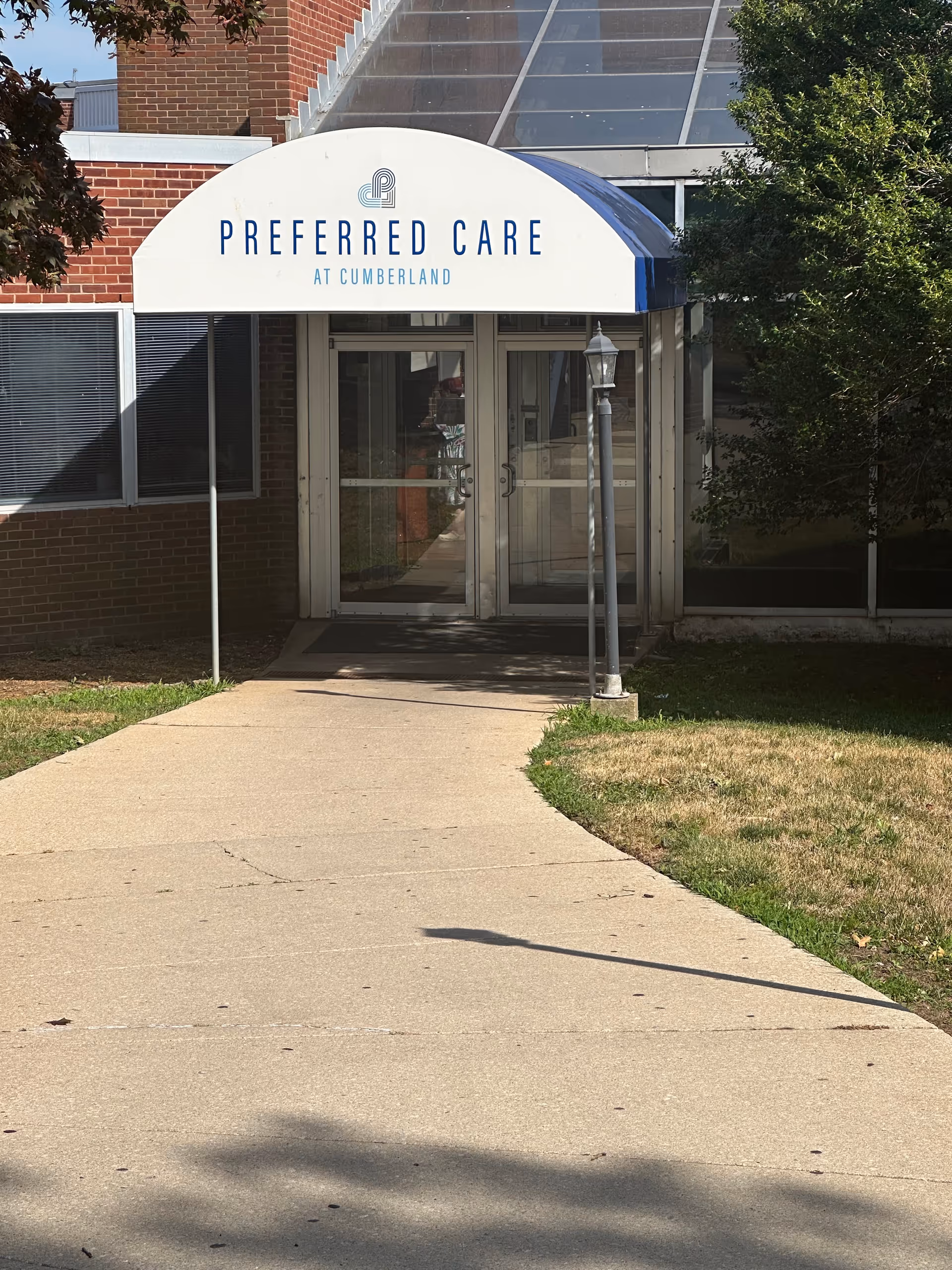 Front entrance of Cumberland facility with curved sign reading Preferred Care at Cumberland.
