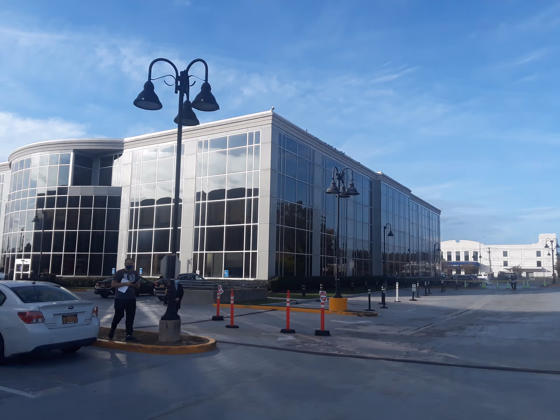 Exterior view of a modern glass-front medical center with parking.