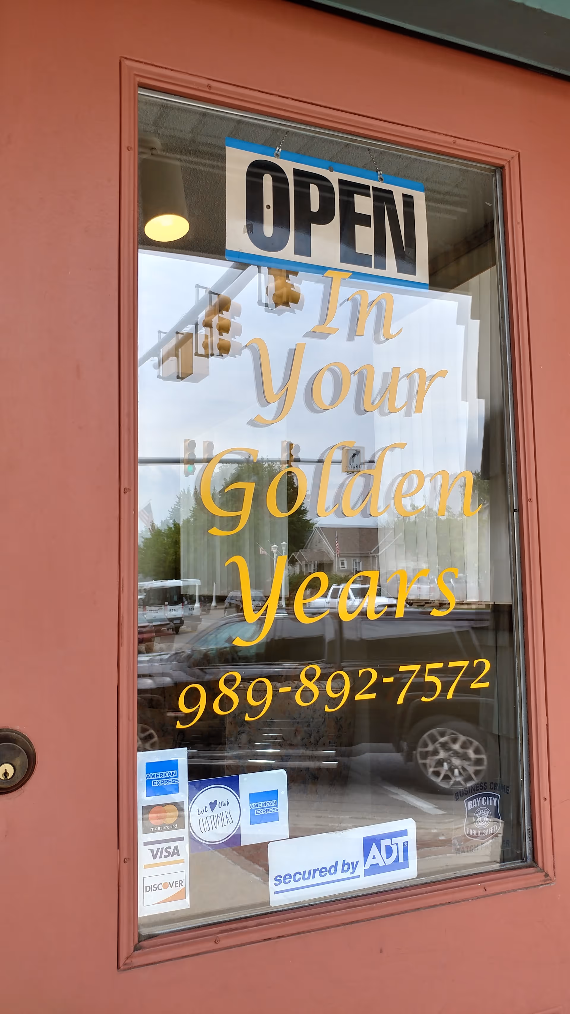 Front entrance window displaying OPEN sign and In Your Golden Years promotional lettering.