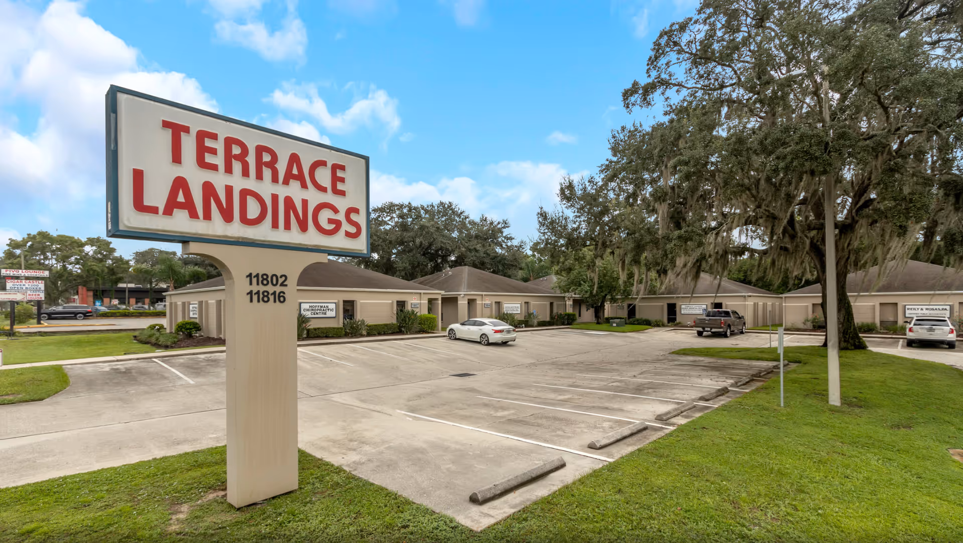 Terrace Landings senior living exterior with a large sign, parking lot, and single-story buildings.