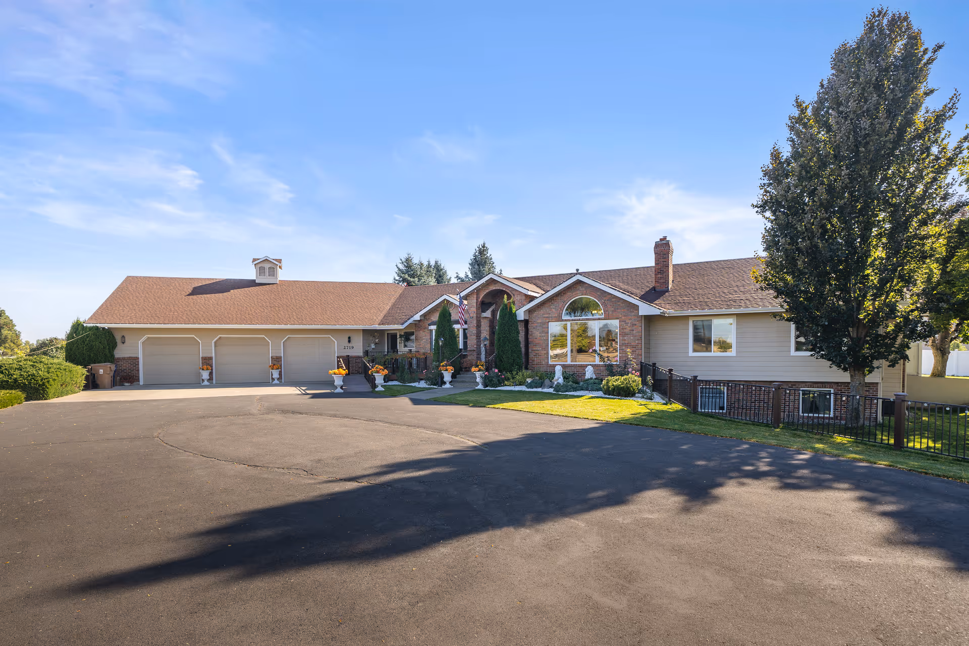 Exterior view of senior living facility with brick front, three garage doors, and landscaped entry.