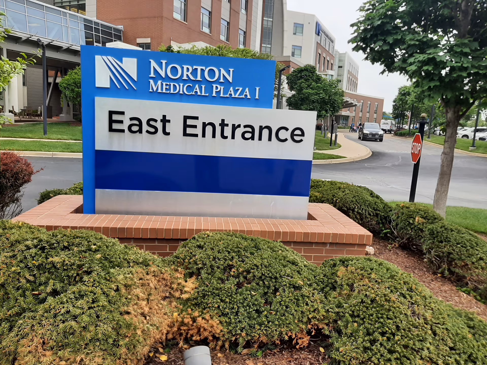 Norton Medical Plaza I East Entrance sign with brick landscaping and surrounding trees.