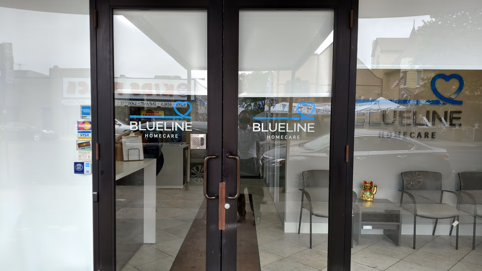 Glass storefront entrance displaying BlueLine HomeCare logo with interior seating.