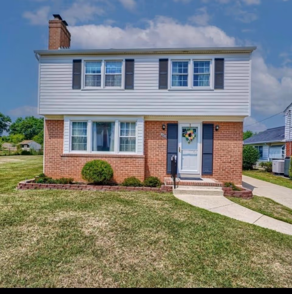 Two-story brick-and-siding house with a front door and a lawn