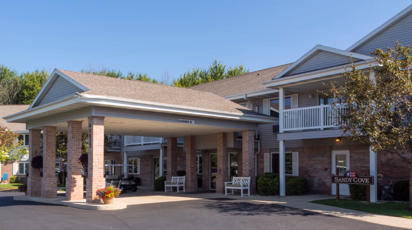 Front exterior of a brick senior living building with a covered driveway.