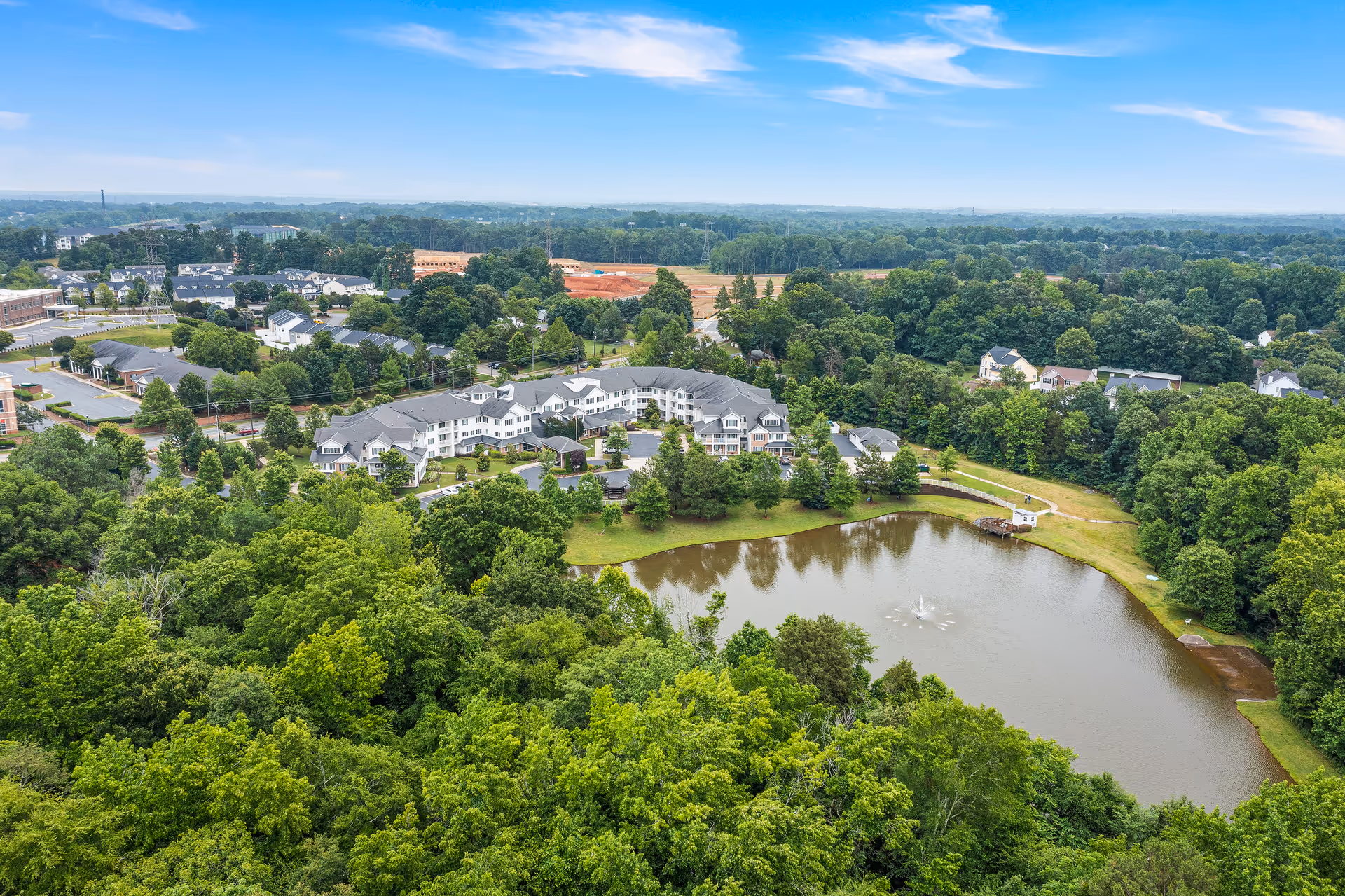 Aerial view of Shads Landing retirement community with ponds, trees, and clustered buildings.