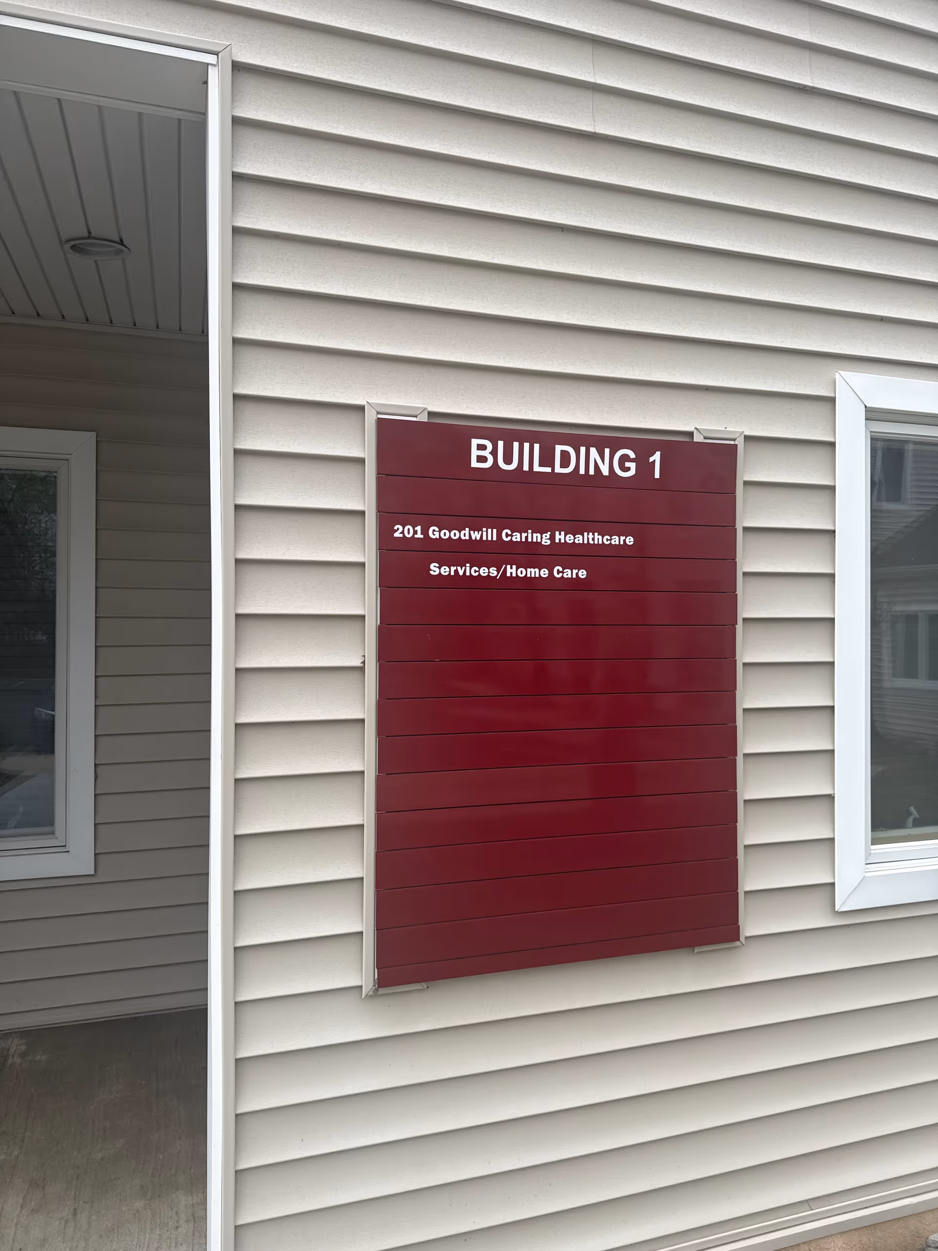 Exterior wall sign reads BUILDING 1 for Goodwill Caring Healthcare Services.