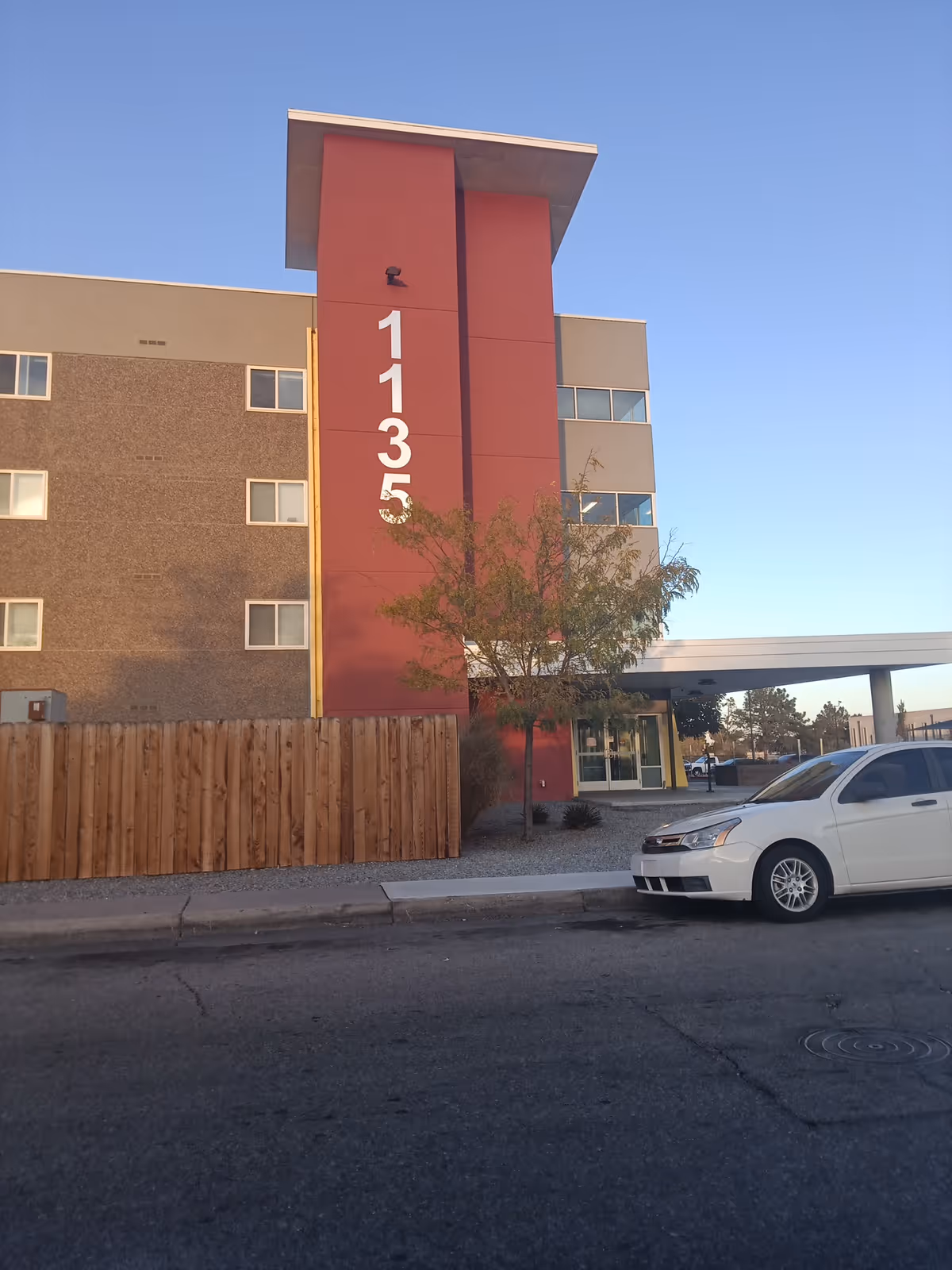 Exterior view of a multi-story senior living building with large vertical address numbers.