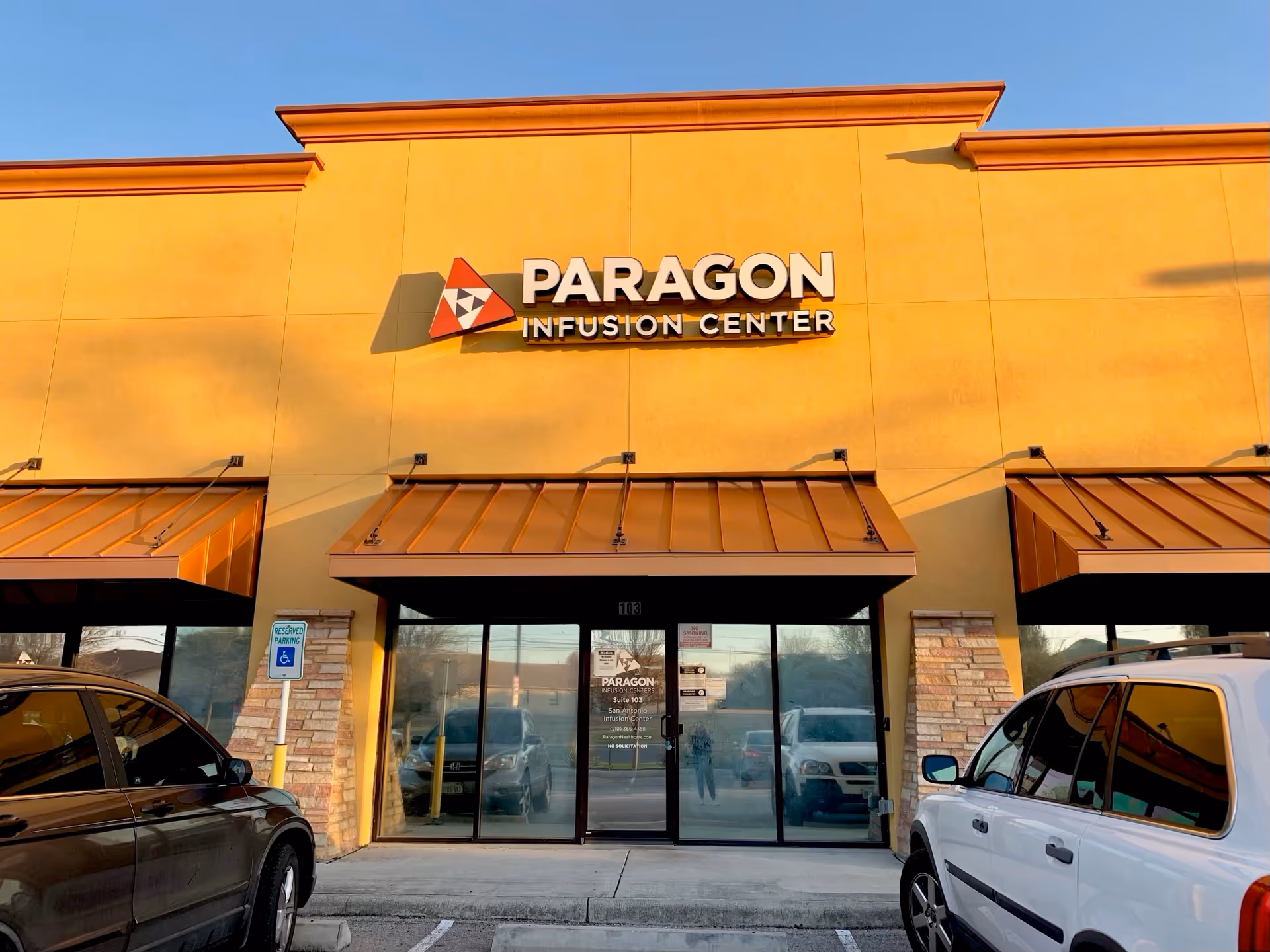 Yellow exterior building with Paragon Infusion Center sign and glass entrance doors.