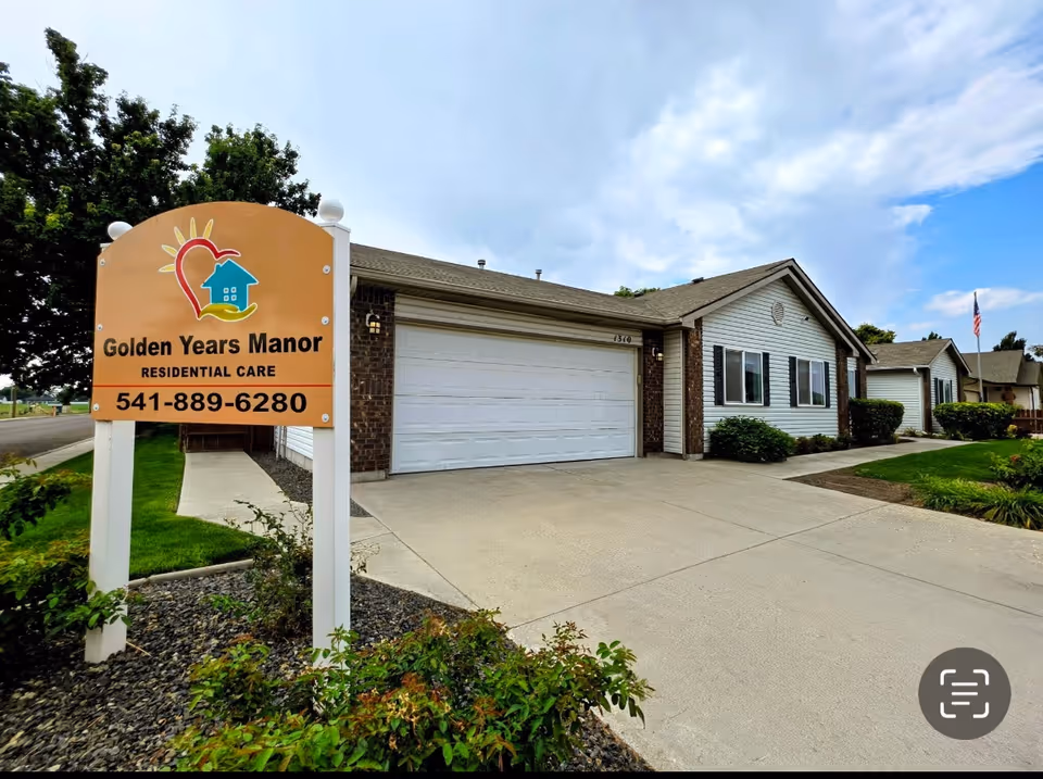 Front exterior of Golden Years Manor senior living facility with sign and driveway.