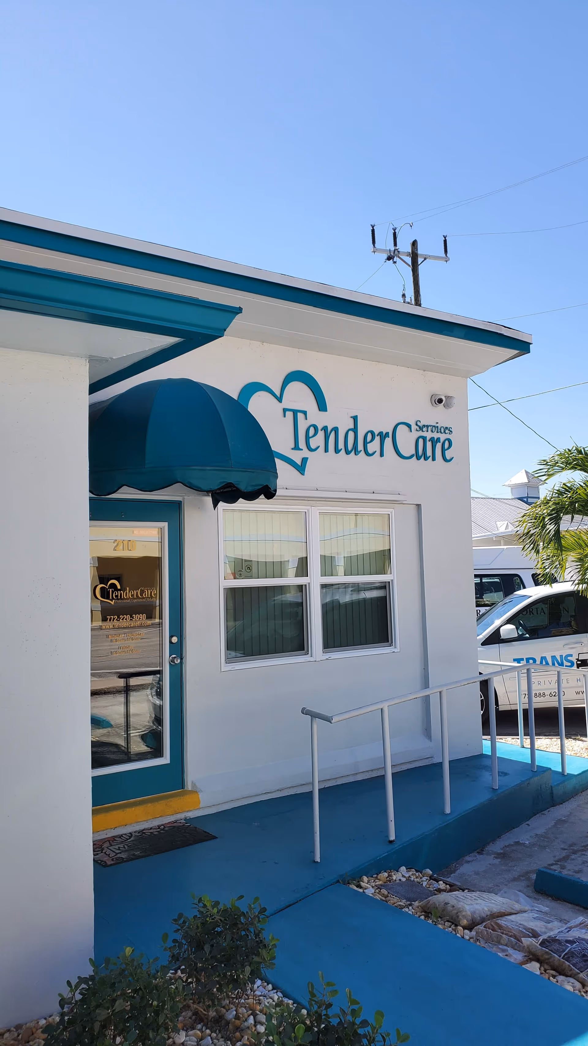 Exterior view of TenderCare Services facility with blue awning and ramp at entrance.