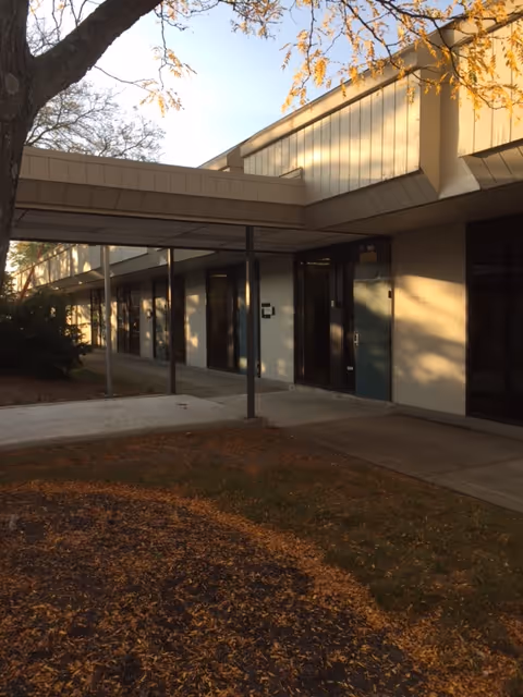 Exterior view of Golden Heart Home Care building with glass doors and walkway.
