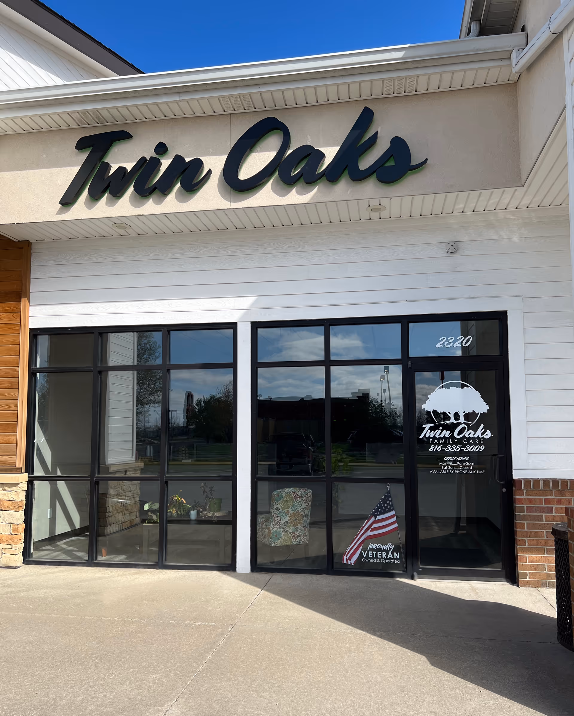 Exterior view of Twin Oaks facility entrance with glass doors and sign.
