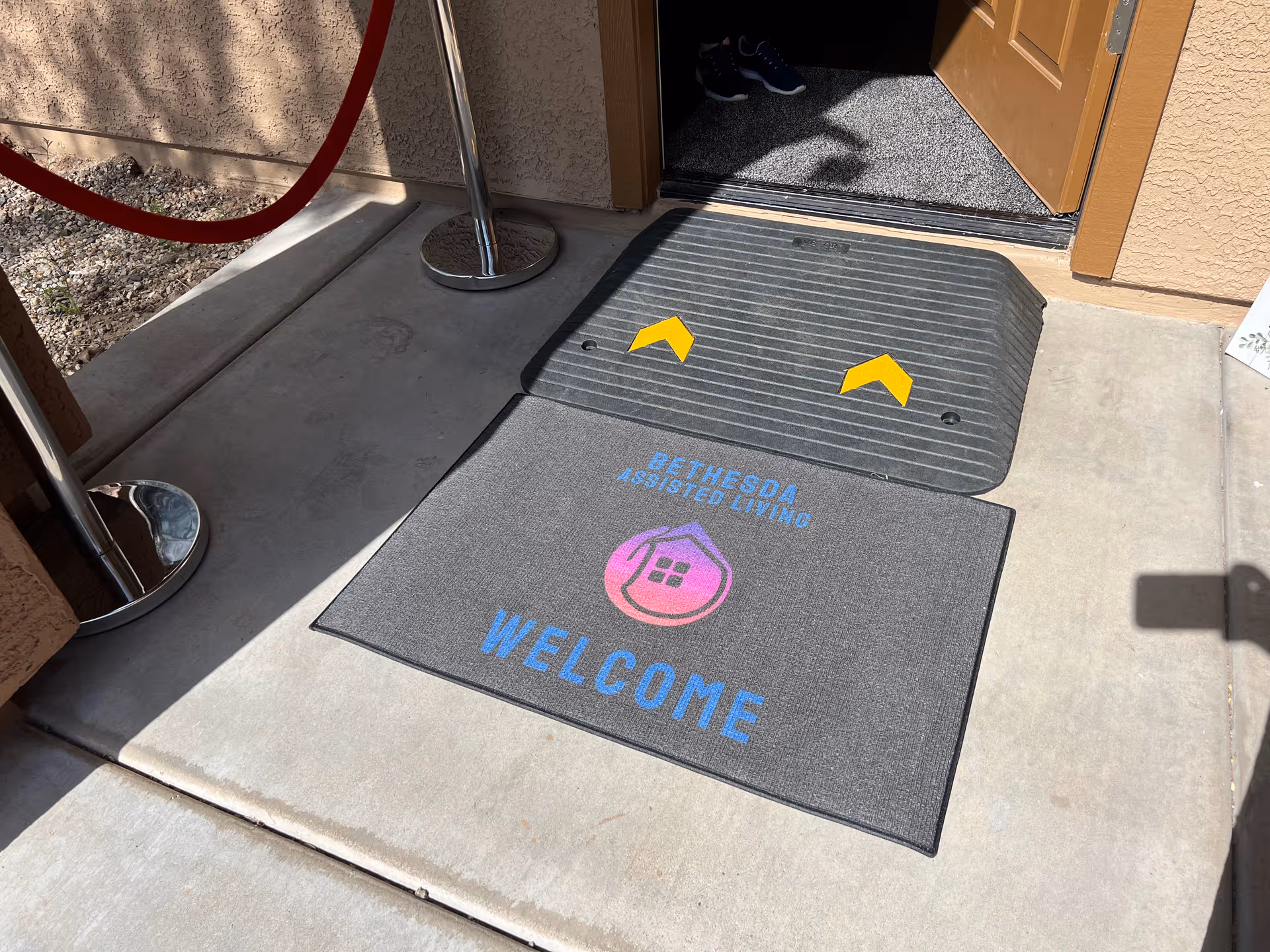 Front entrance to Bethesda Assisted Living with a welcome mat at the doorway.